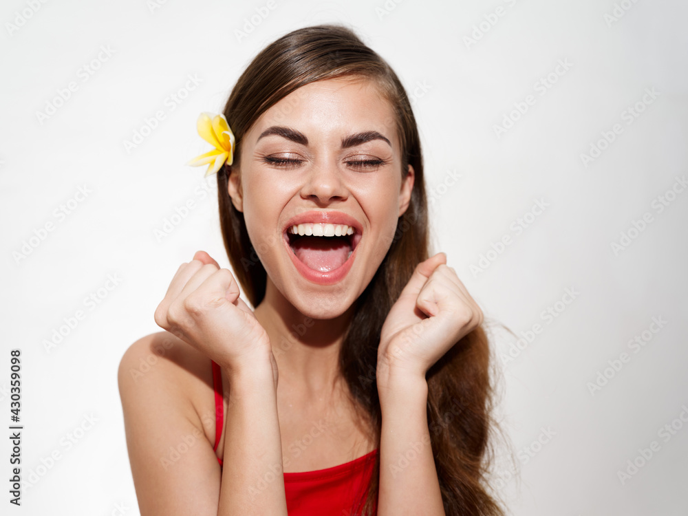happy woman with yellow flower laughs and holds hands in fist on light background cropped view happy woman with yellow flower laughs and holds hands in fist on light background cropped view