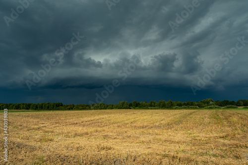 Storm supercell in gray sky over agricultural fields, Czulczyce, Poland