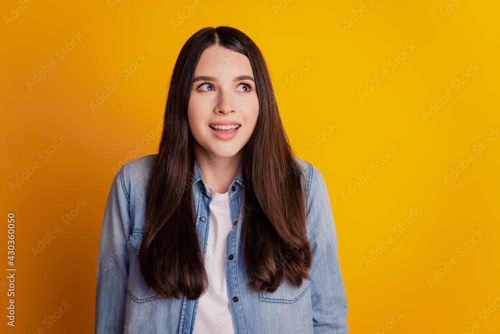 Portrait of happy excited girl look up empty space on yellow wall Portrait of happy excited girl look up empty space on yellow wall