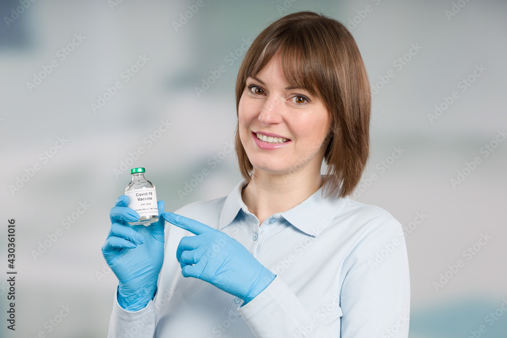 female doctor or nurse is presenting a coronavirus vaccine bottle female doctor or nurse is presenting a coronavirus vaccine bottle