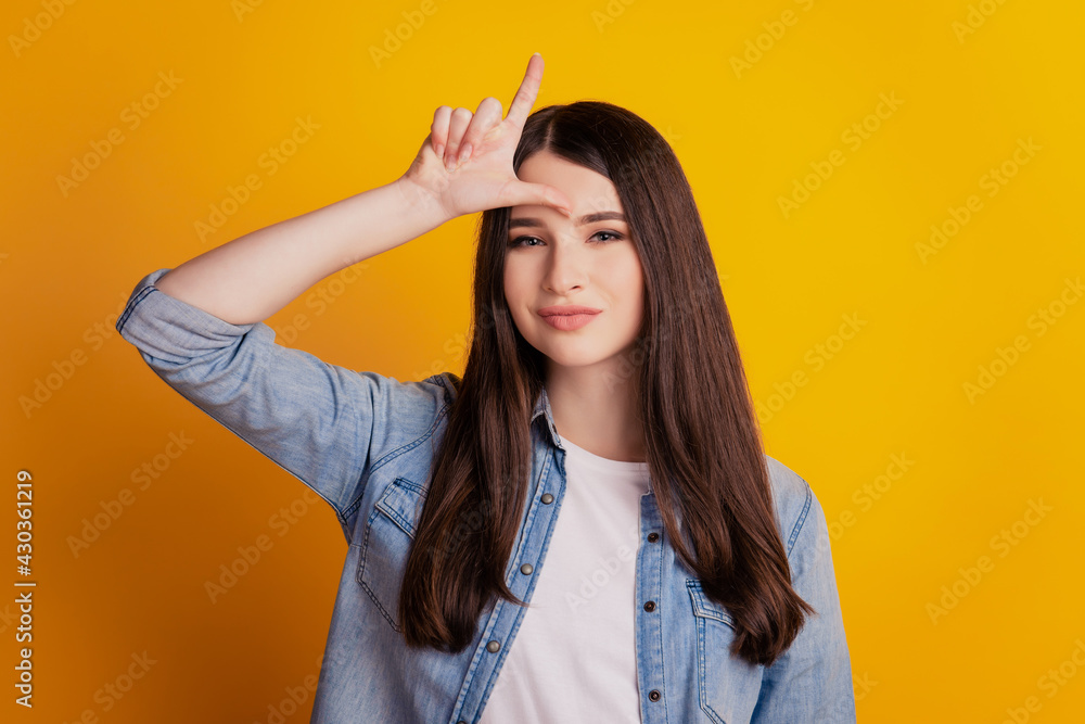 Closeup portrait of lady hold finger forehead point up isolated yellow wall background Closeup portrait of lady hold finger forehead point up isolated yellow wall background