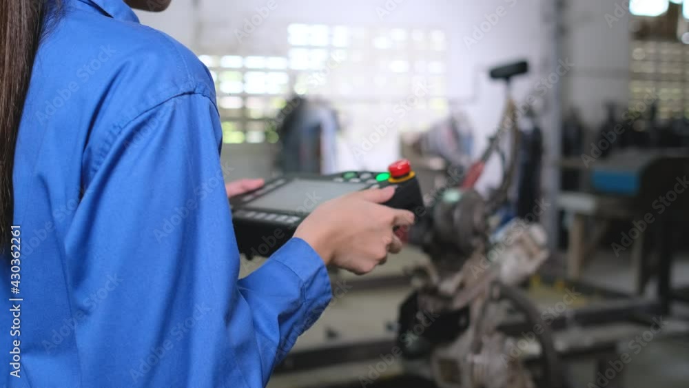 Close up hands of factory worker woman control industrial robot arm