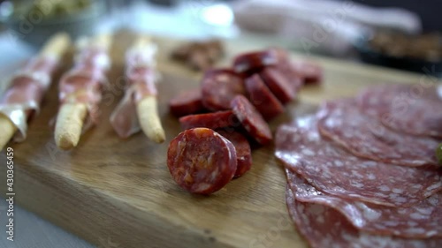Macro close up pan dolly footage over a charcuterie board. Cold cured meats include chorizo, salami and prosciutto. Artisan food footage concept filmed with natural dalight. photo