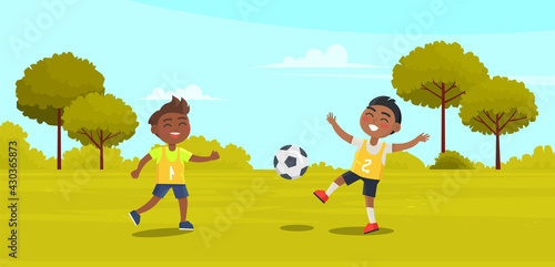 Happy children two boys black footballers playing soccer in park on green grass. The best summer child s outdoor activities. Active weekend outdoors children s games. Kids football on playground