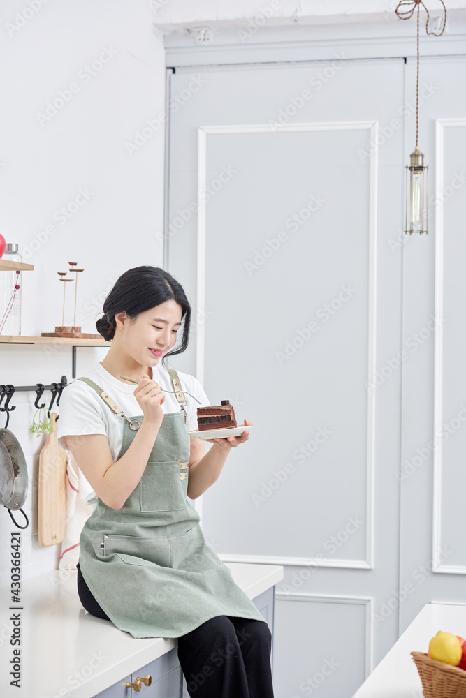 Asia Korean young woman serving a piece of chocolate cake on a plate Asia Korean young woman serving a piece of chocolate cake on a plate