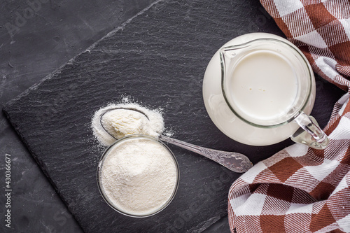 Photos granulated milk powder on a dark stone background