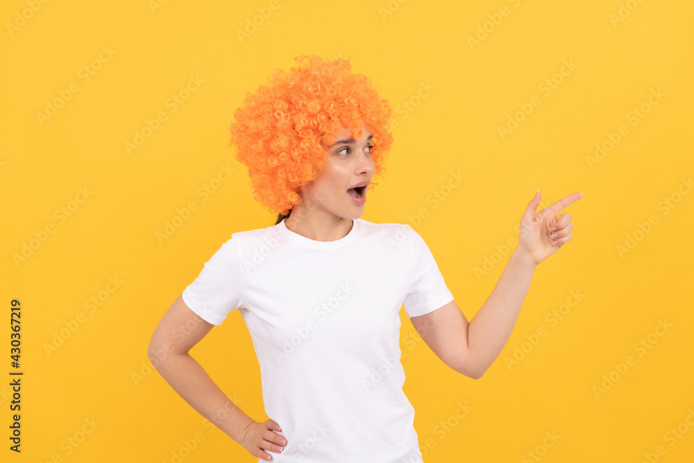 look over there. amazed fancy party look. freaky woman in clown wig pointing finger, copy space