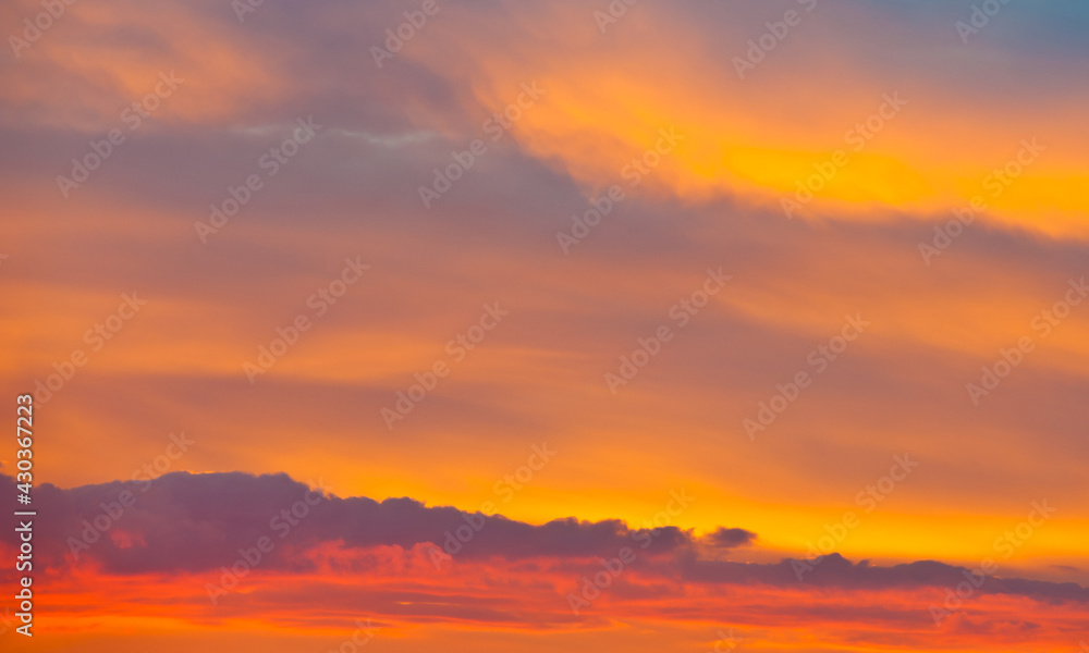 Beautiful orange clouds in the summer sunset sky (background)