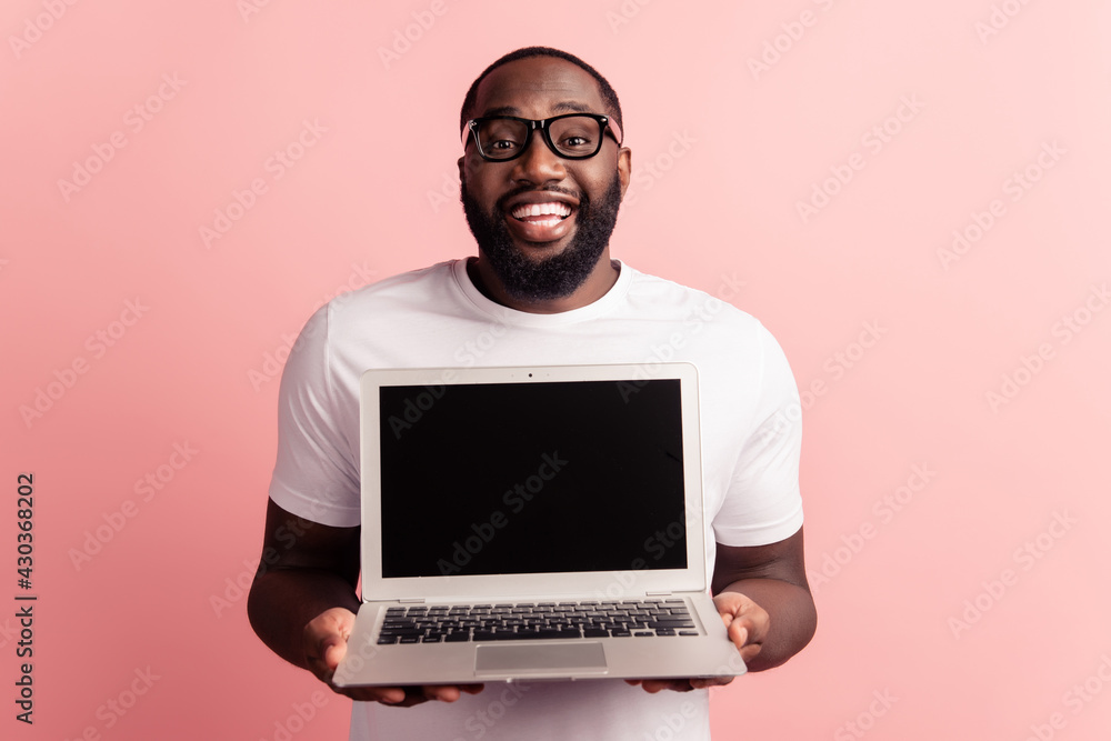 Young smiling african man standing and using laptop computer show desktop empty space Young smiling african man standing and using laptop computer show desktop empty space