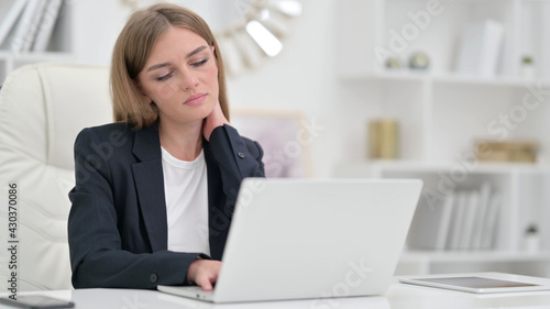 Tired Businesswoman with Laptop having Neck Pain in Office 