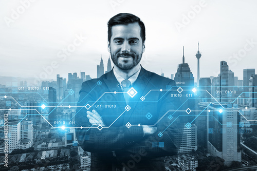 Photography A young Caucasian businessman in crossed arms pose pondering on technology at business process to achieve tremendous growth