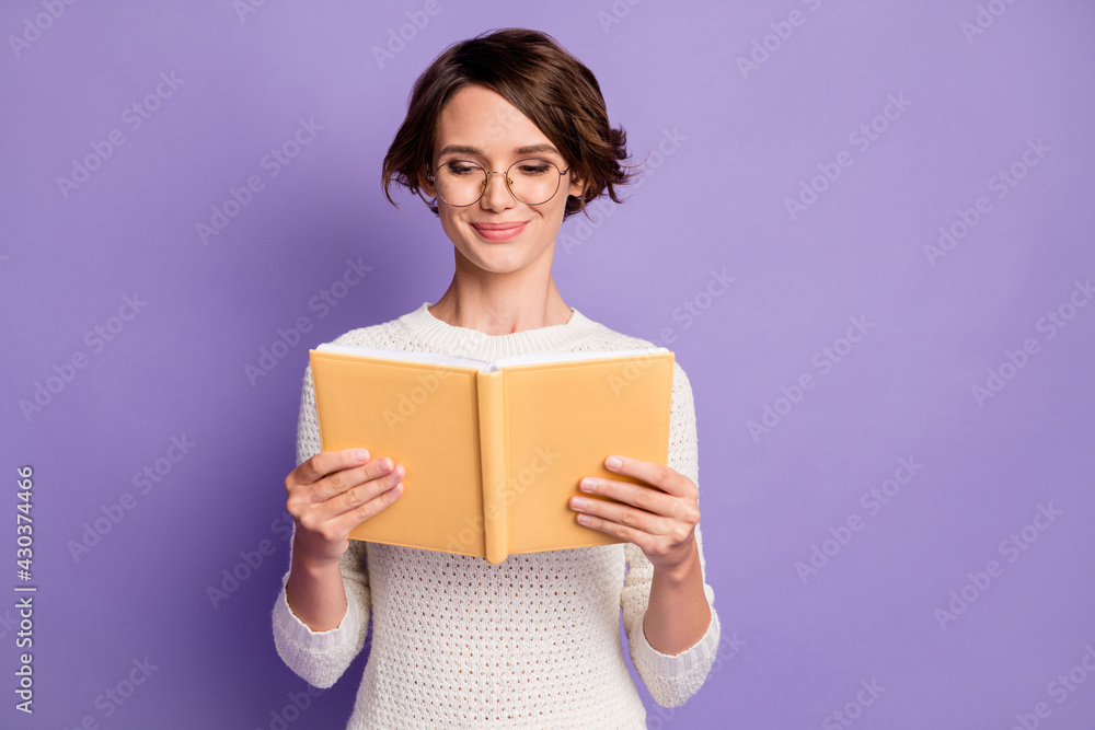 Photo portrait of smart female student reading book preparing for exam isolated on vivid violet color background Photo portrait of smart female student reading book preparing for exam isolated on vivid violet color background