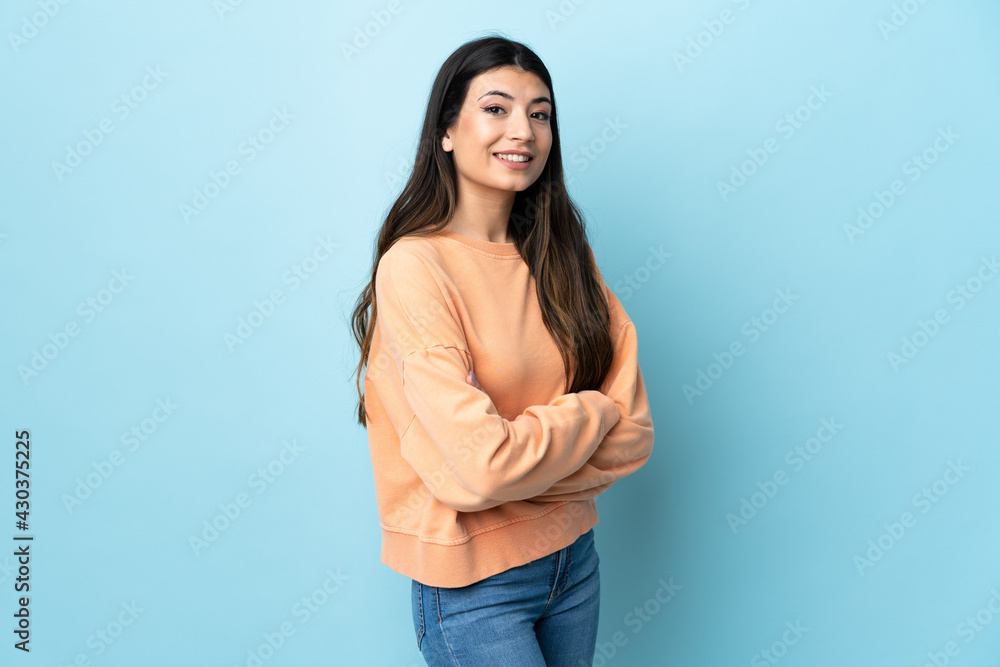 Young brunette girl over isolated blue background looking to the side and smiling Young brunette girl over isolated blue background looking to the side and smiling