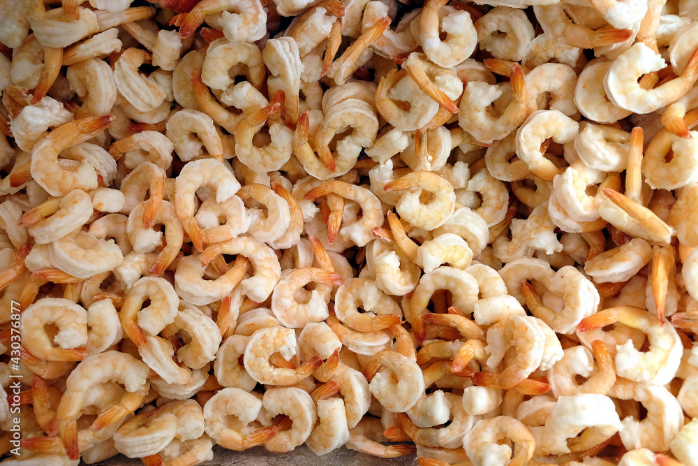 Still-life with lot of frozen peeled pink-white shrimp as background in the freezer in department store shop top view close-up Still-life with lot of frozen peeled pink-white shrimp as background in the freezer in department store shop top view close-up
