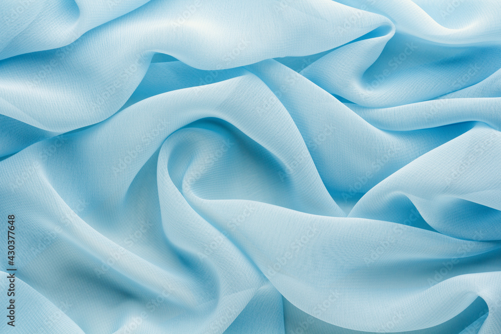 Obraz premium light blue fabric draped with large folds, delicate textile background