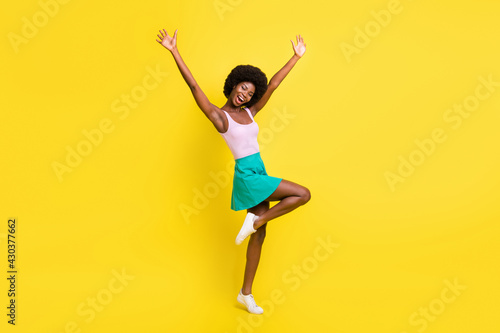 Full body profile side photo of dark skin attractive young woman raise hands celebrate success isolated on yellow color background