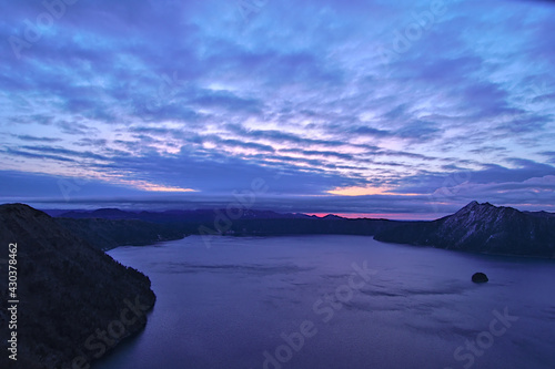 薄い雲の広がる夜明けの湖。日本の北海道の摩周湖。