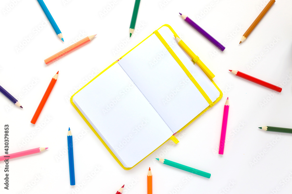 bright open notebook on a white background and bright pencils bright open notebook on a white background and bright pencils