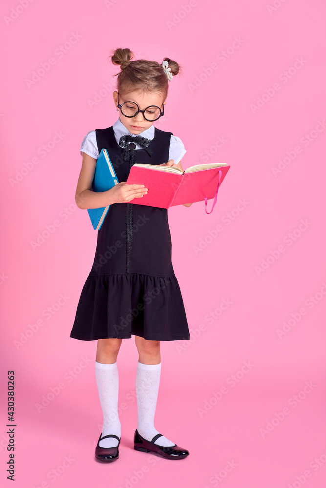 Cute little girl with glasses and books on pink background, spac Cute little girl with glasses and books on pink background, spac