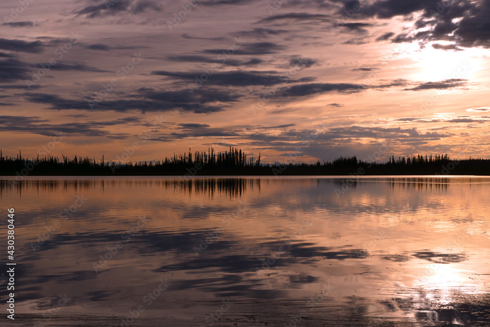 Panoramic Alaska landscape sunset view with lake, boreal forest and mountains