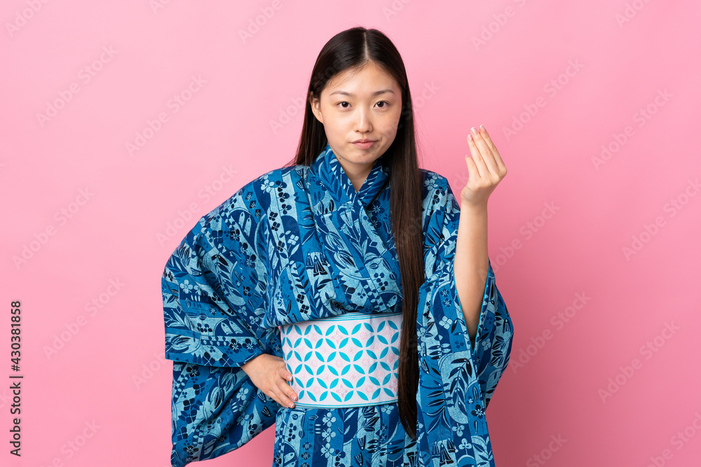 Young Chinese girl wearing kimono over isolated background making Italian gesture Young Chinese girl wearing kimono over isolated background making Italian gesture