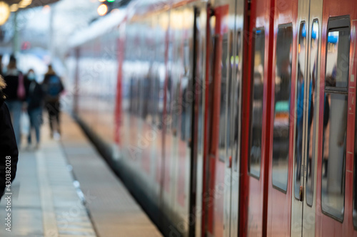 Menschen mit Masken am Bahngleis im Hauptbahnhof Köln bei der Einfahrt des Zuges