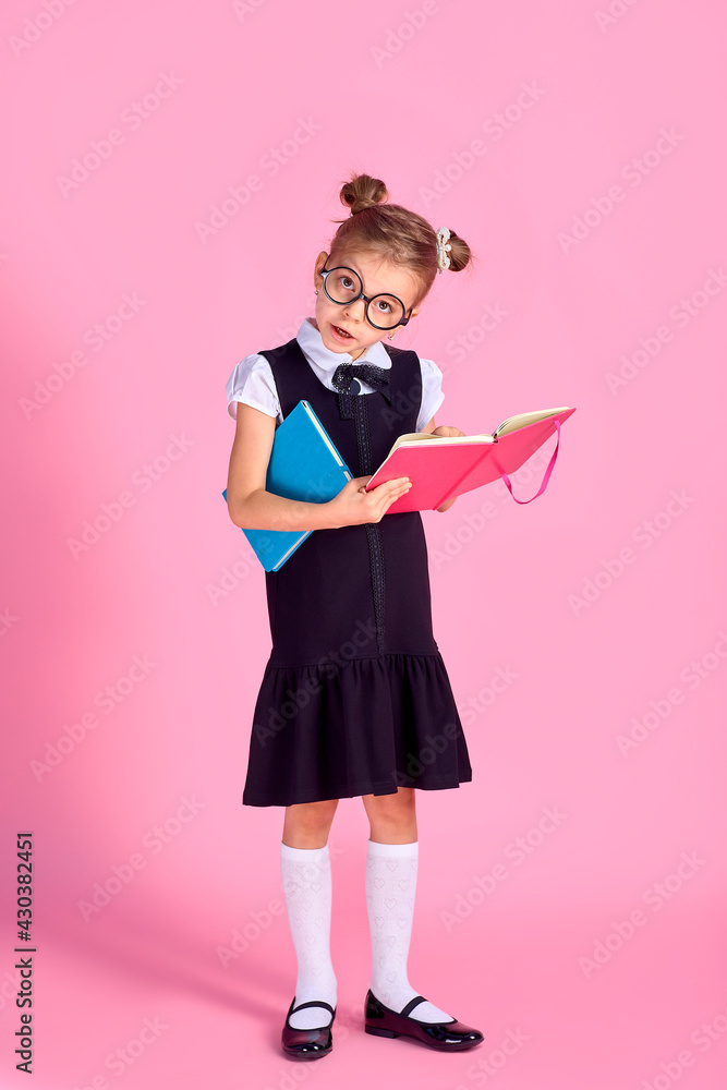 Cute little girl with glasses and books on pink background, spac Cute little girl with glasses and books on pink background, spac