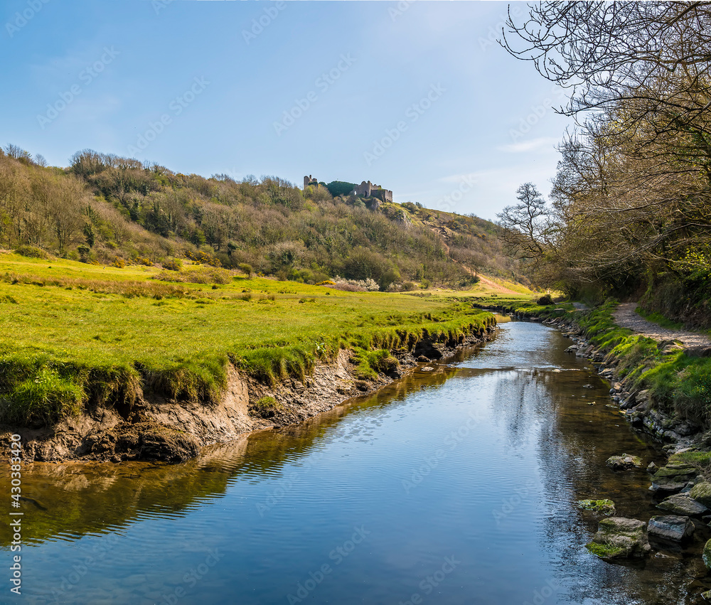 A view along the Pennard Pill stream towards the Three Cliffs Bay, Gower Peninsula, Swansea, South Wales on a sunny day A view along the Pennard Pill stream towards the Three Cliffs Bay, Gower Peninsula, Swansea, South Wales on a sunny day