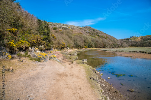 A view along the path beside the Pennard Pill stream from Three Cliffs Bay, Gower Peninsula, Swansea, South Wales on a sunny day