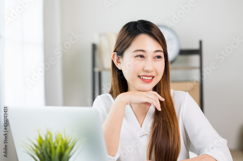 Free Download Young asian beautiful business woman working with laptop sitting at home. Smiling charming happy young female doing homework meeting conference with team at home. - GFXLoad