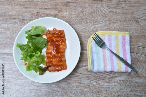 Tteobokki or rice cake Korean food made from flour dressing cheese and red spicy sauce eat couple fresh vegetable on plate photo