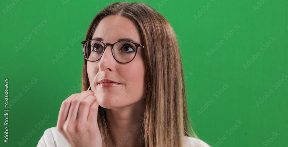 Corona Antigen Self-Test in use - young woman applies a Covid-19 self-test - studio photography Corona Antigen Self-Test in use - young woman applies a Covid-19 self-test - studio photography