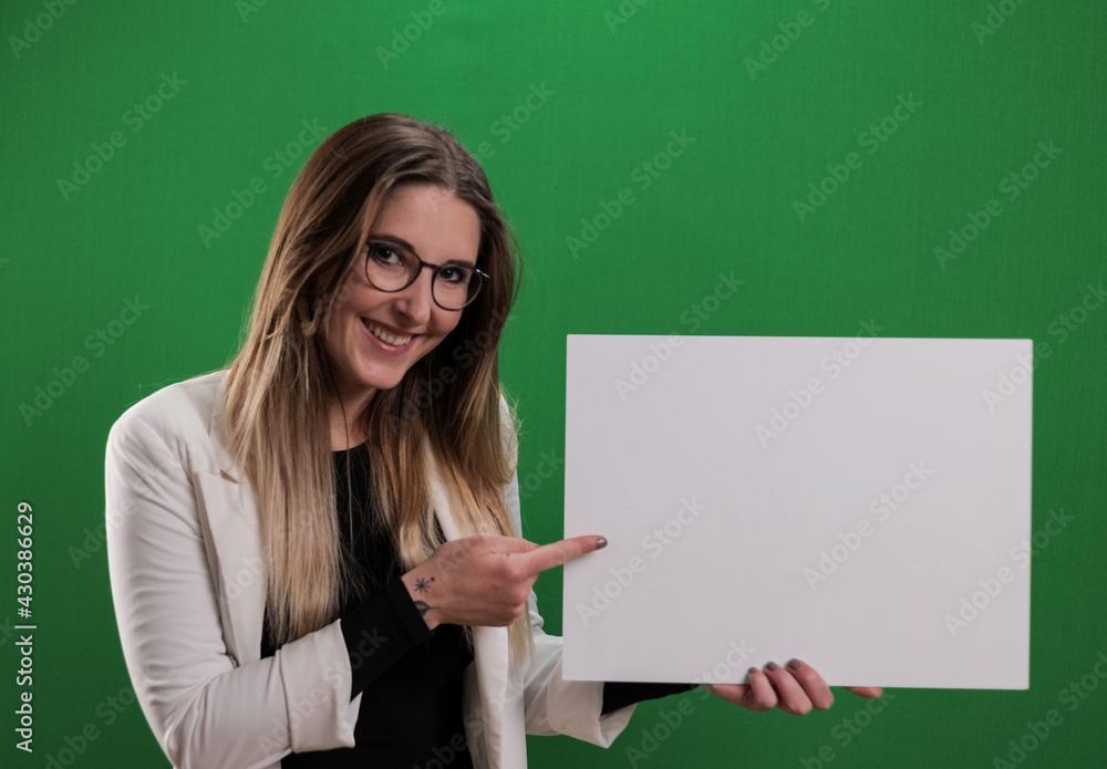 Young pretty woman holds a dummy sign and points to it - studio photography Young pretty woman holds a dummy sign and points to it - studio photography