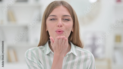 Portrait of Loving Young Woman giving Flying Kiss with Hand