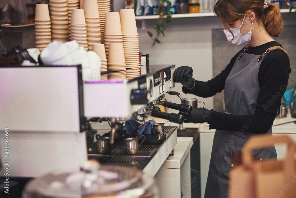 Busy female barista operating coffee machine and making hot beverage Busy female barista operating coffee machine and making hot beverage
