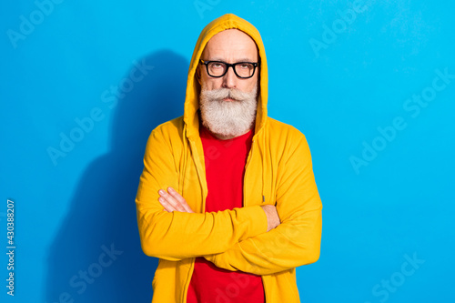 Photo of serious confident cool mature businessman in glasses crossed arms wear tracksuit isolated on blue color background