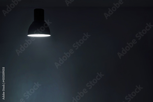 a shining levitating hanged ceiling lamp without electric wire with dark blue tone dirty concrete background wall.