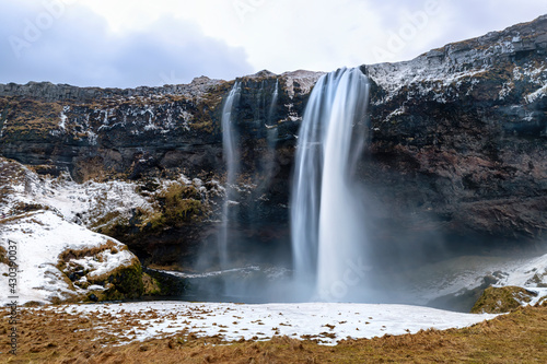 Front view of the Seljalandsfoss waterfall in southern Iceland. This spectacular fall has a 60 metre drop and is part of the Seljalands River. Long exposure. photo