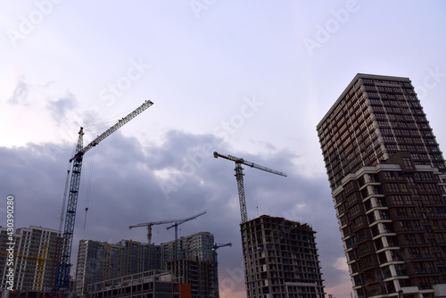 Tower crane on construction of a residential building. Cranes on formworks. Construction the building or multi-storey homes. Instal concrete wall rebar. Renovation concept. Realtor and Real Estate
