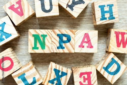 Alphabet letter block in word NPA (Abbreviation of Non performing assets or Nasopharyngeal airway) with another on wood background photo