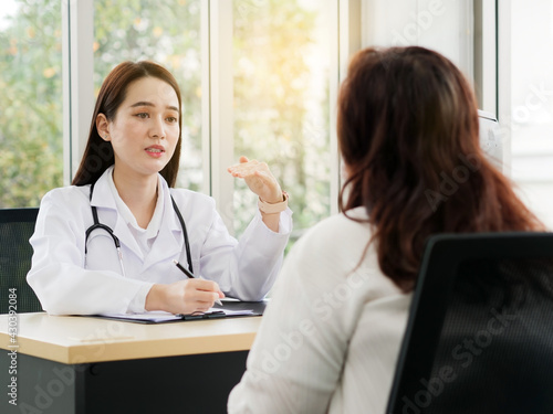 A female doctor or nurse is talking or interview a middle-aged female patient, ideas for healthcare concepts.