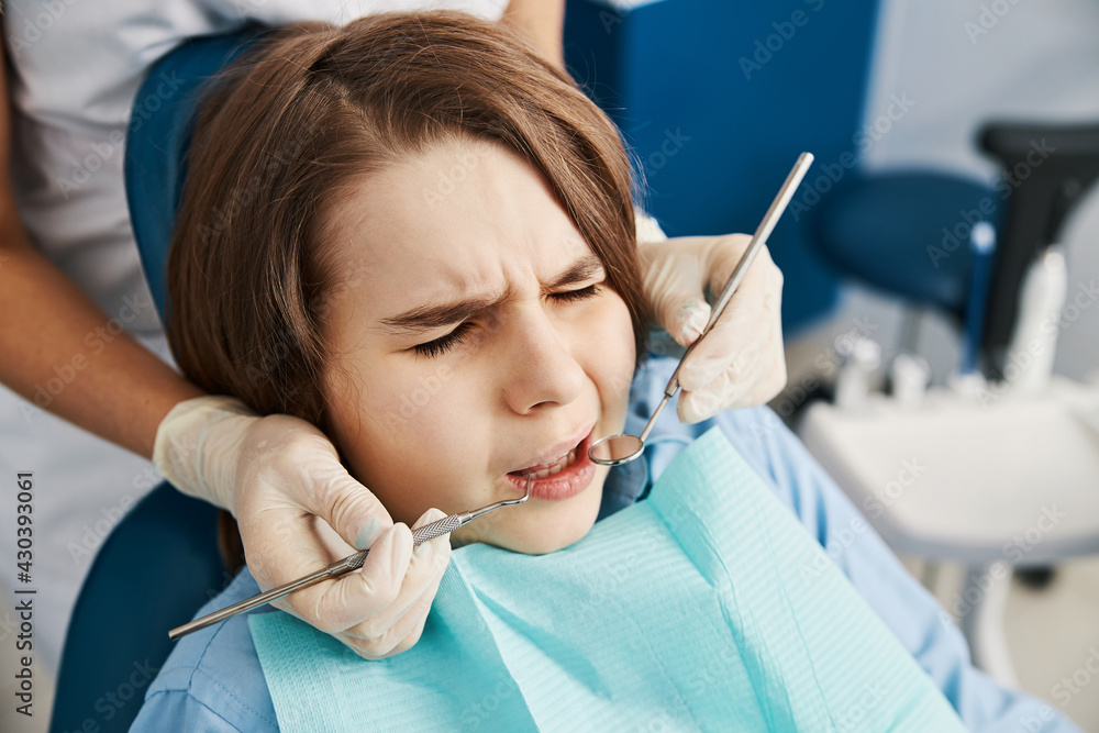 Child patient squinting with fear of dental instruments Child patient squinting with fear of dental instruments