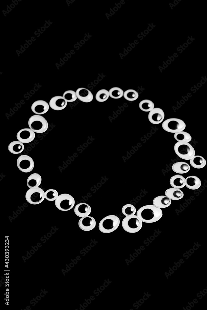 A circle of toy eyes on a black background A circle of toy eyes on a black background