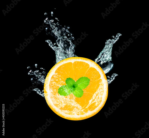 Fototapeta Naklejka Na Ścianę i Meble -  Fresh sliced orange fruit in water splash isolated on black background