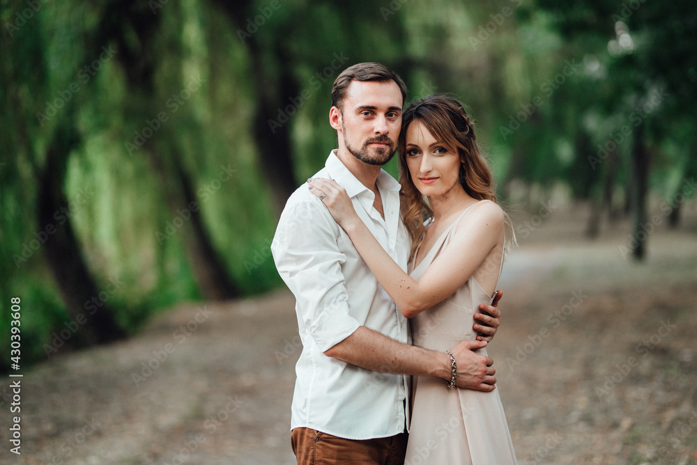 a guy and a girl are walking along the banks of a wild river overgrow a guy and a girl are walking along the banks of a wild river overgrow