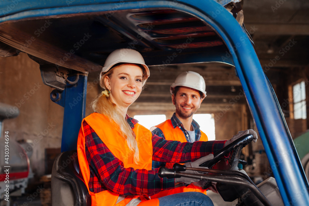 Happy woman forklift driver smiling, looking at the camera Happy woman forklift driver smiling, looking at the camera