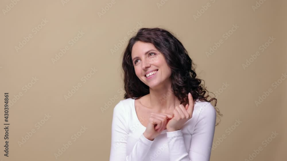 Dreamful happy brunette woman think of pleasant things with cheerful positive smile at beige background. Isolated closeup portrait of charming female of 30s enjoy dreams, excited memories or thoughts Dreamful happy brunette woman think of pleasant things with cheerful positive smile at beige background. Isolated closeup portrait of charming female of 30s enjoy dreams, excited memories or thoughts