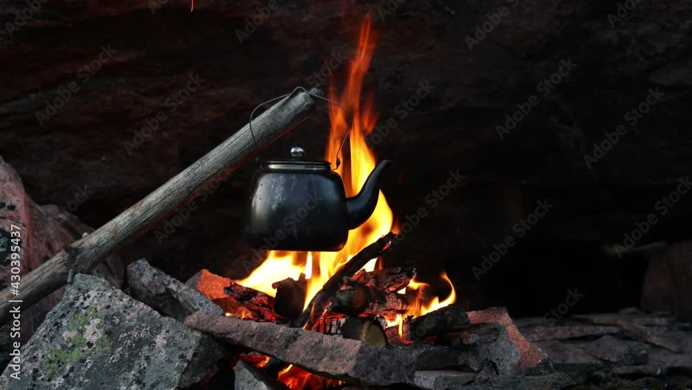 Teapot on the fire close up. Kettle heating on a bonfire. Making hot drink coffee or tea. Outdoor recreation concept.
Teapot on the fire close up. Kettle heating on a bonfire. Making hot drink coffee or tea. Outdoor recreation concept.