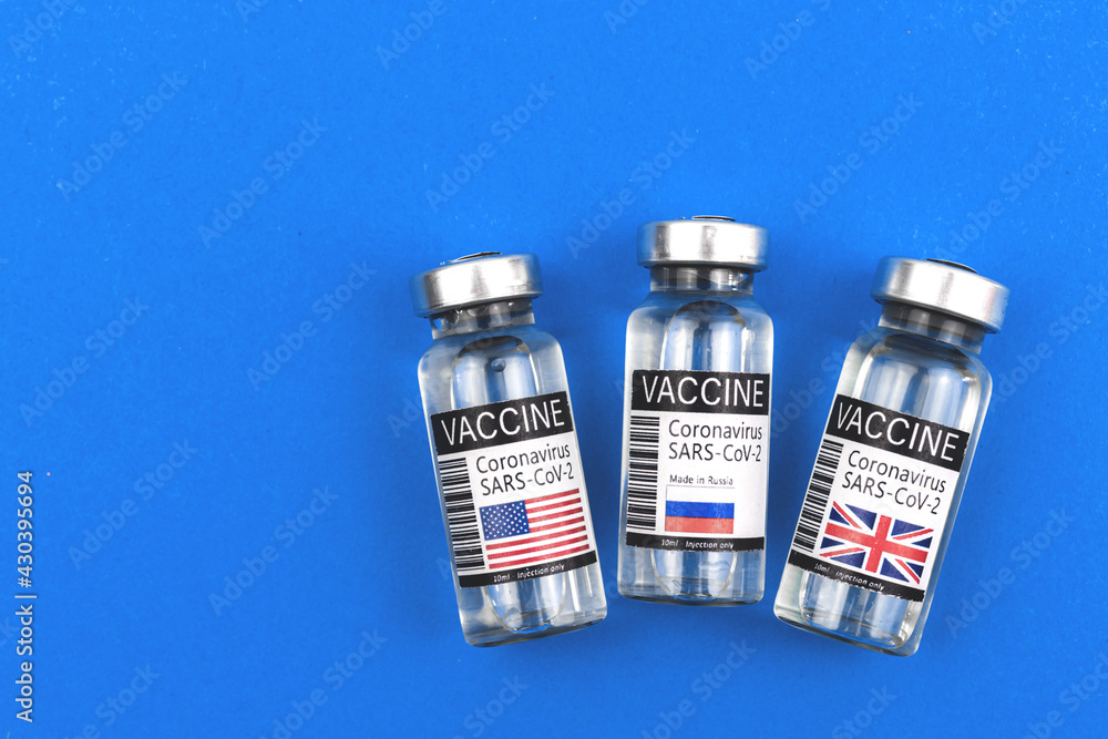 COVID-19 vaccine development concept, USA, Russia and UK flag on vaccine vials, vaccination and immunization background COVID-19 vaccine development concept, USA, Russia and UK flag on vaccine vials, vaccination and immunization background