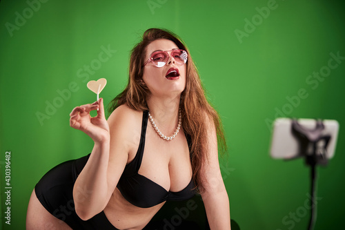 Fotografie Female in suggestive clothing enjoying taste of lollipop